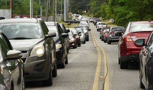 Cars line up for a food giveaway held at Cathedral of the Cross in Center Point, Alabama. Twenty-pound boxes of fresh fruit and vegetables were given away to anyone who needed it. Image: al.com/Joe Songer via TNS
