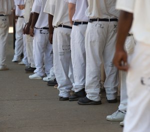 In this June 18, 2015 file photo, prisoners stand in a crowded lunch line during a prison tour at Elmore Correctional Facility in Elmore, Ala.