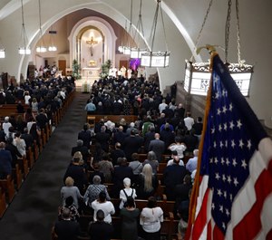 Mourners stand during the funeral Mass for Detective Luis Alvarez, at Immaculate Conception Church, in the Queens borough of New York, Wednesday, July 3, 2019. (AP Photo/Richard Drew, Pool)