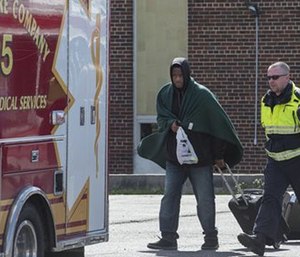 Train passenger Sadarein Walker is escorted to a waiting ambulance after an Amtrak train crash in Chester, Pa. (Clem Murray/The Philadelphia Inquirer via AP)