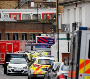The train, on which a homemade bomb exploded, stands above parked police vehicles on a road below at Parsons Green subway station in London, Friday, Sept. 15, 2017.