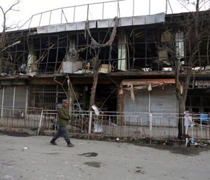 A member of Afghan security forces walks past the site of Saturday's suicide attack in Kabul, Afghanistan. (Photo/AP)