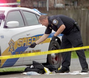 A St. Charles Parish Sheriff's deputy investigates the scene where Cpl. Burt Hazeltine was shot multiple times while directing traffic in a school zone Thursday, April 16, 2015, in Paradis, La.
