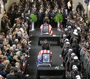 Jamal Knox’s rap song’s lyrics contained a reference to Richard Poplawski who murdered three Pittsburgh officers in 2009. In this April 8, 2009, file photo family and officials pay their respects to those three Pittsburgh police officers. (AP Photo/Gene J. Puskar, File)