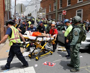 Rescue personnel help injured people after a car ran into a large group of protesters after an white nationalist rally in Charlottesville, Va., Saturday, Aug. 12, 2017. (AP Photo/Steve Helber)