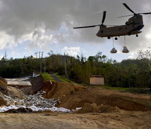 A U.S. Army helicopter transports material to repair the Guajataca Dam, damaged during Hurricane Maria, in Quebradillas, Puerto Rico.