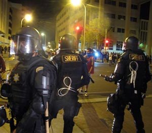 In this March 30, 2014 file photo, riot police stand guard near a crowd protesting police shootings in Albuquerque, N.M.