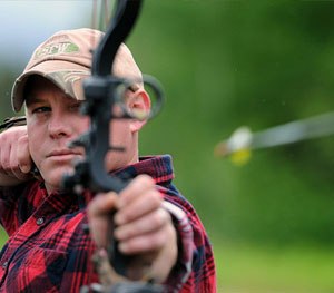 Army Sgt. Josh Leavitt releases an arrow at a target on the base archery range during the 19th annual Military Appreciation Picnic and Arctic Warrior Olympics.
