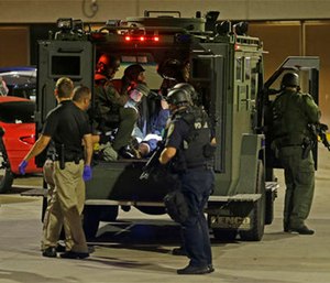 Armed police officers transport an injured man in an armored vehicle to a hospital Milwaukee, Sunday, Aug. 14, 2016. Shots rang out during unrest after a police shooting that killed a man Saturday. Police said one person was shot at a Milwaukee protest on Sunday and officers used an armored vehicle to retrieve the injured victim and take the person to a hospital, as tense skirmishes erupted for a second night following the police shooting of a black man. (AP Photo/Jeffrey Phelps)