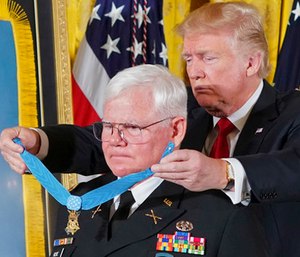 President Donald Trump bestows the nation's highest military honor, the Medal of Honor, to retired Army Capt. Gary M. Rose, during a ceremony in the East Room of the White House in Washington. (AP Photo/Pablo Martinez Monsivais)