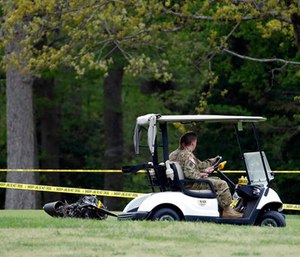 Investigators examine debris that fell on the Breton Bay Golf and Country Club after an Army UH-60 helicopter from Fort Belvoir, Va., crashed, Monday, April 17, 2017, in Leonardtown, Md. (AP Photo/Alex Brandon)