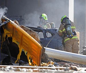 Emergency personnel work at a light plane crashed in Melbourne, Australia, Tuesday, Feb. 21, 2017. The plane crashed into a shopping mall, officials said.