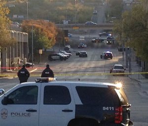 Police tape marks off the scene after authorities shot and killed a man who they say opened fire on the Mexican Consulate, police headquarters and other downtown buildings early Friday, Nov. 28, 2014, in Austin, Texas. In the distance, police cars surround the suspect's vehicle parked near the Interstate 35 overpass.