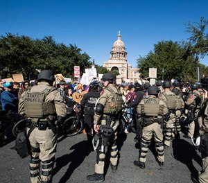 Police in riot gear separate counter-protestors from a White Lives Matter rally outside the Texas State Capitol in Austin, Texas, on Saturday, Nov. 19, 2016. (Dave Creaney/Austin American-Statesman via AP)