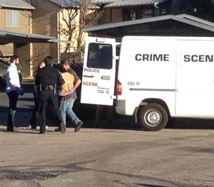 Police officers carry potential evidence from the Austin apartment where shooting suspect Larry McQuilliams lived.