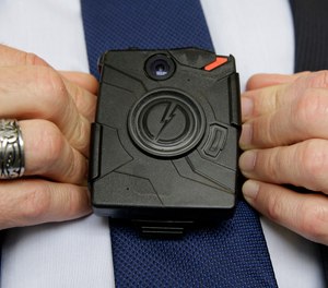 In this Feb. 19, 2015 file photo, Steve Tuttle, vice president of communications for Taser International, demonstrates one of the company's body cameras during a company-sponsored conference at the California Highway Patrol Headquarters in Sacramento, Calif.