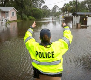 A City of Tybee police officer checks the well being of a resident fleeing her flooded home on Tybee Island, Ga., Monday, Sept., 11, 2017. Parts of the coastal Georgia island suffered from Tropical Storm Irma. (AP Photo/Stephen B. Morton)