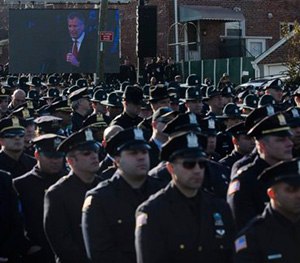 Police officers turn their backs as New York City Mayor Bill de Blasio speaks at the funeral of New York city police officer Rafael Ramos.