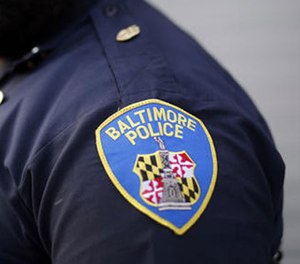 In this March 31, 2016, file photo, Baltimore Police Department Officer Jordan Distance stands on a street corner during a foot patrol in Baltimore.