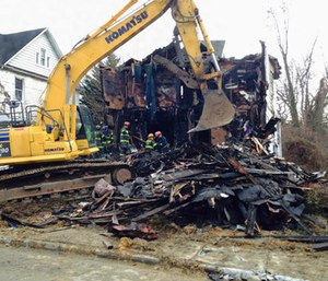 Firefighters examine the debris at a Baltimore home that caught fire early on Thursday, Jan. 12.