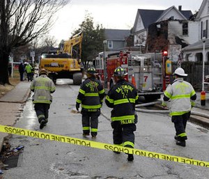Fire officials approach the scene of an early morning house fire in Baltimore, Thursday, Jan. 12, 2017.