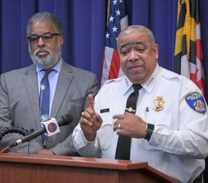 City solicitor Andre Davis, left, listens as Baltimore Police Commissioner Michael Harrison, right, announces support for a pilot program that uses surveillance planes over the city to combat crime on Friday, Dec. 20, 2019, in Baltimore.