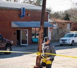 A law enforcement officer removes crime scene tape in front of Mac's Lounge, the scene of an early morning bar shooting, in Hartsville, S.C. (Photo/AP)