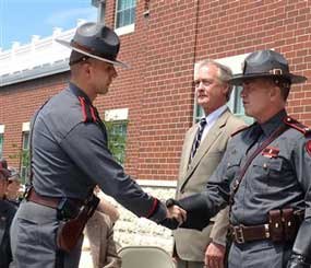 Rhode Island State Trooper Roupen Bastajian, left, shakes the hand of Col. Steven O’Donnell, head of the State Police, as he is awarded the service ribbon, the State Police’s highest honor on Thursday, May 16, 2013, in Scituate, R.I. (AP Image)