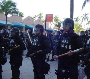 Riot police with batons at protests against the Free Trade Area of the Americas in Miami.