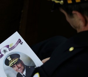 An 18th District officer holds the program for the funeral mass of slain Chicago police Cmdr. Paul Bauer at Nativity of Our Lord Roman Catholic Church in Chicago on February 17, 2017. (Photo/TNS)