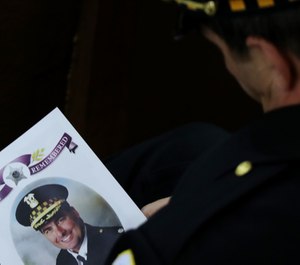 An 18th District officer holds the program for the funeral mass of slain Chicago police Cmdr. Paul Bauer at Nativity of Our Lord Roman Catholic Church in Chicago on February 17, 2017.