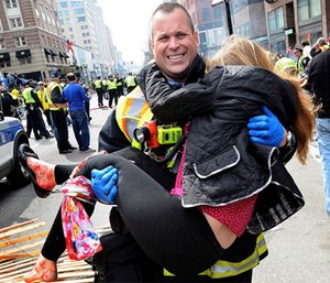 Boston firefighter Jimmy Plourde carries injured Victoria McGrath away from the scene after a bombing near the finish line of the Boston Marathon. (Ken McGagh / MetroWest Daily News via AP)