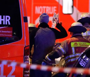 Firefighters attend an injured person after a truck ran into crowded Christmas market in Berlin, Germany, Monday, Dec. 19, 2016.