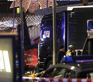 Police stand beside a damaged truck which ran into crowded Christmas market in Berliin Berlin, Germany, Monday, Dec. 19, 2016.