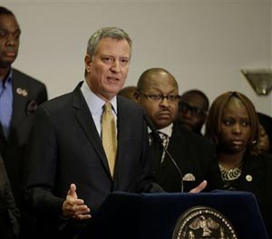 New York City Mayor Bill de Blasio, surrounded by community leaders, speaks to reporters about the grand jury's decision in the Eric Garner case in the borough of Staten Island in New York, Wednesday, Dec. 3, 2014. (AP Image)