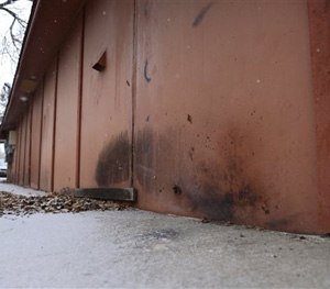 This Jan. 6, 2015 photo shows at the bottom right the char marks from a device detonated Tuesday along the northeast corner of a building occupied by a barber shop near the Colorado Springs chapter of the NAACP in Colorado Springs, Colo.