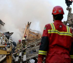 Firefighters work to remove debris of the Plasco building.