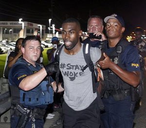 Police arrest activist DeRay McKesson during a protest along Airline Highway, a major road that passes in front of the Baton Rouge Police Department headquarters Saturday, July 9, 2016, in Baton Rouge, La.