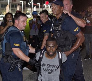 In this July 9, 2016, file photo, police officers arrest DeRay Mckesson for blocking Airline Highway during a protest in Baton Rouge, La.