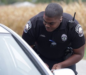In this file photo taken on Tuesday, Sept. 29, 2015, a body camera is attached to the uniform of Whitestown Police Department officer Reggie Thomas during a traffic stop, in Whitestown, Ind.