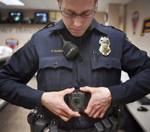 In this Feb. 16, 2017 photo, Maplewood Police Officer Parker Olding attaches his body camera to the magnetic plate worn inside his uniform in Maplewood, Minn.