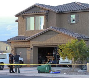 Police point to the window of a Maricopa home on Tuesday, Sept. 27, 2016, where a Border Patrol agent was found dead inside after exchanging gunfire with officers responding to a domestic violence call. (Howard Waggner/Maricopa Monitor via AP)