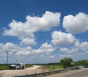 In this Aug. 11, 2014 photo, a Border Patrol agent sits on the levee in Mission, Texas. On Aug. 6, 2014, a few hundred yards down the levee, Border Patrol agents arresting immigrants mistook seven armed militia members who helped detain immigrants for state troopers. (AP Image)