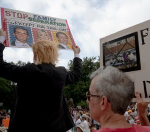 Heidi Turpin, left, dressed as President Donald Trump, holds up a sign next to her husband, Jim, during a protest against detaining migrant children, Thursday, July 4, 2019, in Austin, Texas. (Nick Wagner/Austin American-Statesman via AP)
