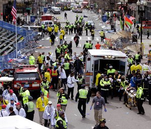 In this April 15, 2013, file photo, medical workers aid injured people following an explosion at the finish line of the 2013 Boston Marathon in Boston.