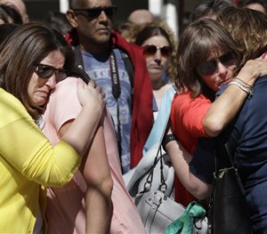 A moment of silence at one of two blast sites near the finish line of the Boston Marathon, in Boston, Wednesday, April 15, 2015.