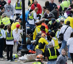 In this Monday, April 15, 2013 file photo, medical workers aid injured people at the finish line of the 2013 Boston Marathon following an explosion in Boston. Over 13,000 videos and 120,000 photos were sent to police during the investigation.