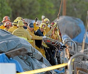 Firefighters remove a lifeless body, believed to be child from the water after a car went off the berth and into the water at the San Pedro Slip, in San Pedro, Calif., Thursday, April 9, 2015. The two children pulled from the submerged vehicle were hospitalized in grave condition, authorities said. (AP Photo/The Daily Breeze, Steve McCrank)
