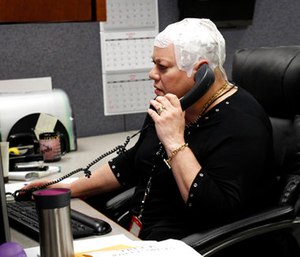 Joyce Endresen wears an Optune therapy device for brain cancer as she speaks on a phone at work in Aurora, Ill.