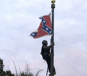 Bree Newsome of Charlotte, N.C., climbs a flagpole to remove the Confederate battle flag at a Confederate monument in front of the Statehouse in Columbia, S.C.